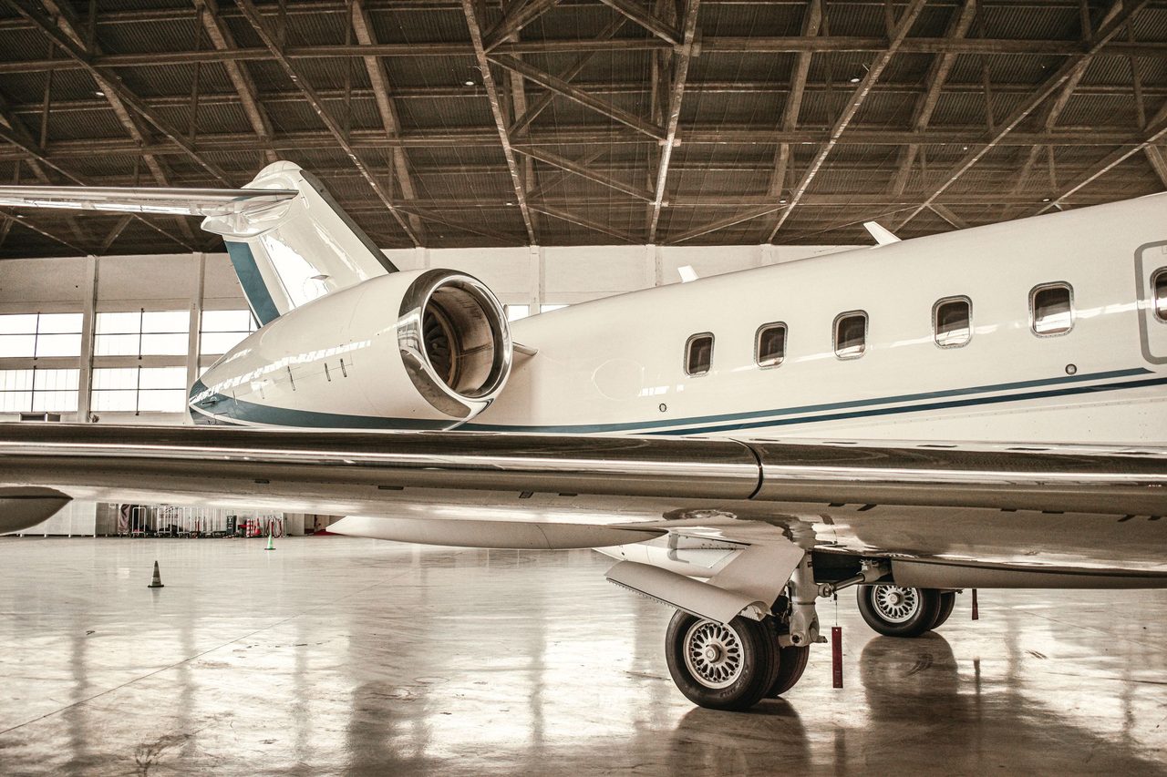 White private jet parked inside a spacious hangar